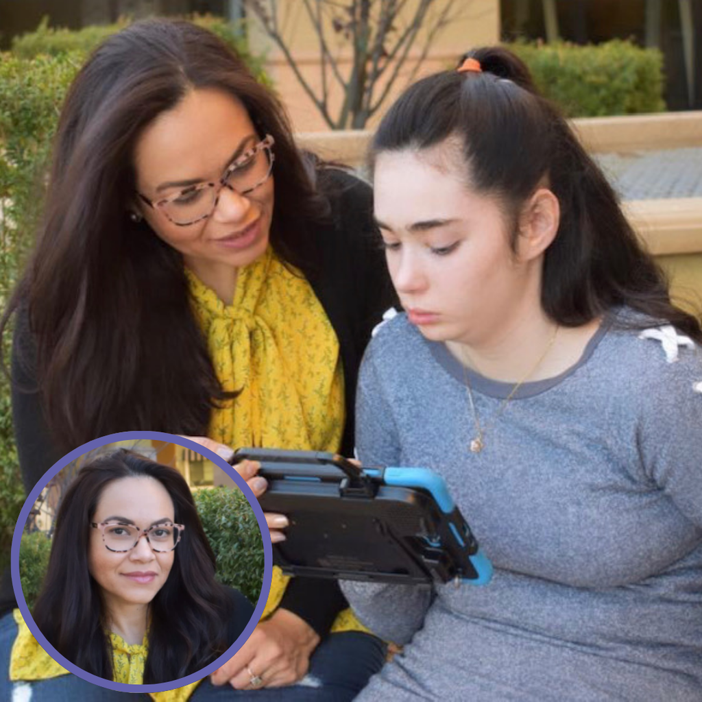 Two women engaged in AAC implementation, one using a tablet while the other provides support, outdoors with greenery.