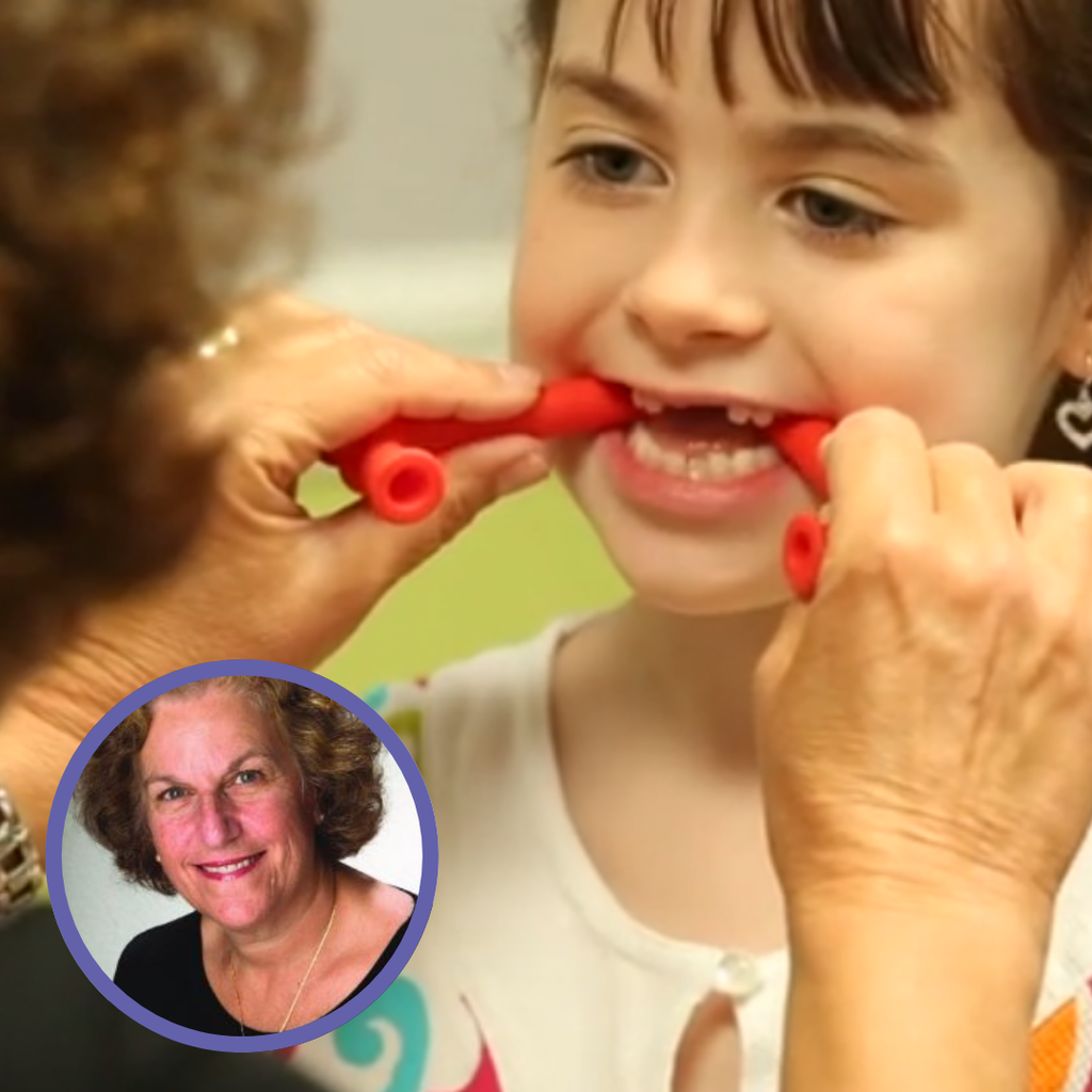 Child practicing speech therapy with red tools, assisted by an adult. 