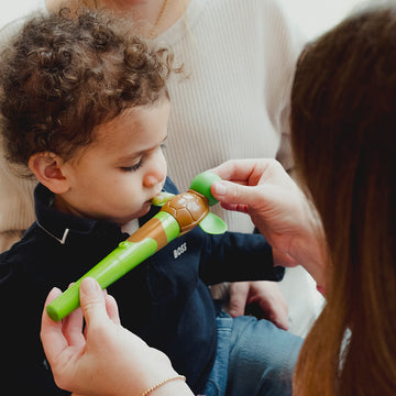 Speech-language pathologist using a jiggler tool in oral placement therapy with a child